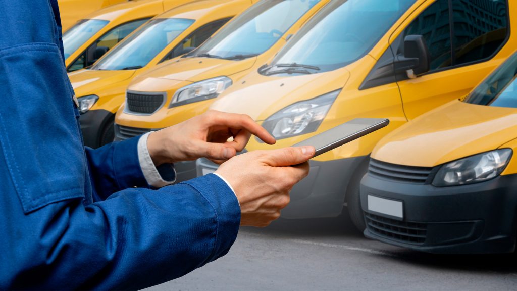 Uomo con tablet che gestisce veicoli commerciali leggeri attraverso soluzioni WAY per la gestione flotte